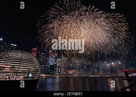 Explosion des goldenen Feuerwerks über der beleuchteten Stadt in der Marina Bay bei Nacht, Singapur Stockfoto