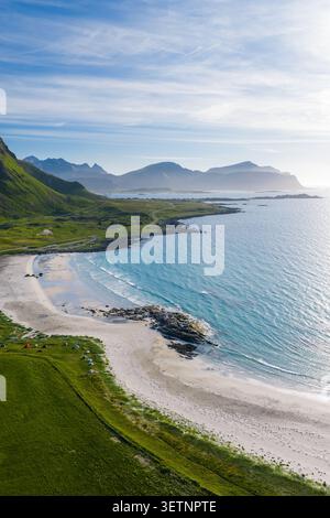 Aus der Vogelperspektive auf den Strand der Lofoten, das Arktische Meer, Zelte und nebelige Gipfel Stockfoto