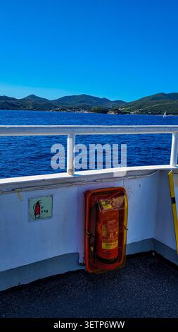 Piombino, Toskana, Italien - 14. September 2024. Sicherheitsausrüstung für die Brandbekämpfung an Bord einer Blu Navy Fähre mit Panoramablick auf das Meer. Stockfoto