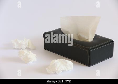 Schwarze Taschentücher mit gezogenen Taschentüchern und zerknitterten weißen Papiertüchern Stockfoto