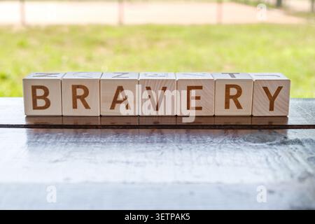 Tapferkeit, Motivationswort aus Buchstaben auf Holzwürfeln Stockfoto