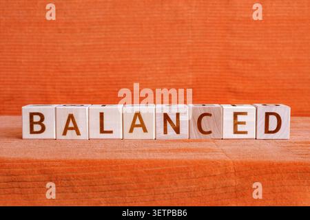 Ausgewogenes, motivierendes Wort aus Buchstaben auf Holzwürfeln Stockfoto