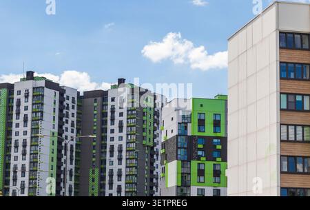 Moderne Apartmentgebäude mit grünen und weißen Fassaden unter blauem Himmel Stockfoto