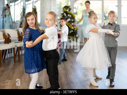 Jugendliche in eleganten Outfits üben im Weihnachtsstudio Partnertanz Stockfoto