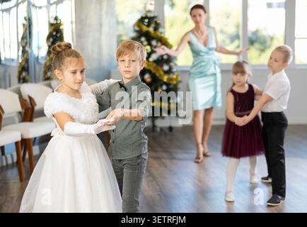 Jugendliche in eleganten Outfits üben im Weihnachtsstudio Partnertanz Stockfoto