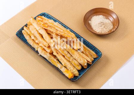 Gebratene Süßkartoffelstäbchen serviert mit Pflaumenpulver-Dipping-Sauce auf Teller. Stockfoto