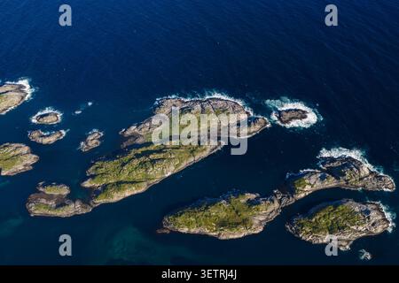 Atemberaubender Blick aus der Vogelperspektive auf den dramatischen felsigen Archipel der Lofoten, umgeben von tiefblauem Atlantikwasser mit moosbedeckten Gipfeln Stockfoto