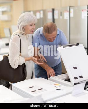 Ein älteres Ehepaar kauft in einem Geschäft ein und wählt eine Waschmaschine Stockfoto