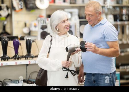 Ältere Ehepaare wählen einen Haarfön mit verschiedenen Stylingmodi Stockfoto