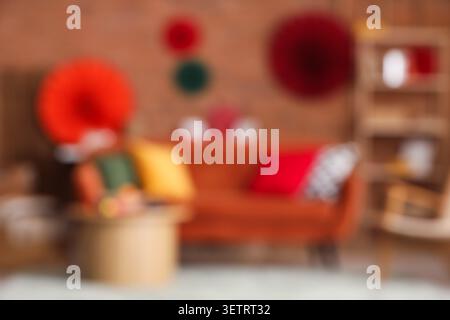 Verschwommener Blick auf das Wohnzimmer mit rotem Sofa, Tisch und Dekor für chinesisches Neujahrsfest Stockfoto