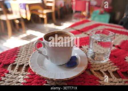 Türkischer Kaffee serviert mit einem Glas Wasser auf einem Tisch in einem Café Stockfoto