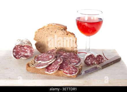 Getrocknete Wurst und Brot vor weißem Hintergrund Stockfoto