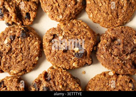 Ein Blick von oben nach unten auf eine Schicht glutenfreier, milchfreier Haferflocken-Rosinenkekse als Hintergrund. Stockfoto