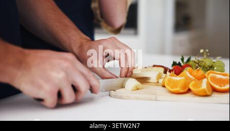 Obstsalat, Hände und Wellness mit Paar in der Küche des Hauses zusammen für Diät oder Ernährung. Essen, Zutaten und Rezept mit gesunden Menschen bei Stockfoto