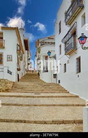 Eine enge Straße mit Treppen zwischen wunderschönen weißen Häusern in der alten spanischen Stadt. Altea. Spanien. Stockfoto