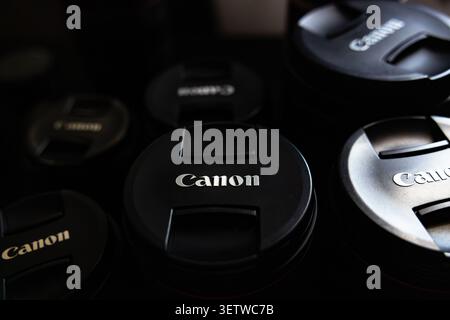 Lemberg, Ukraine - 21. Juni 2026: Gruppe professioneller Canon Kameraobjektive mit Schutzkappen auf dunklem Hintergrund Stockfoto