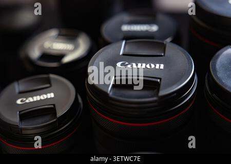 Lemberg, Ukraine - 21. Juni 2026: Gruppe professioneller Canon Kameraobjektive mit Schutzkappen auf dunklem Hintergrund Stockfoto