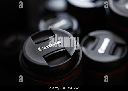 Lemberg, Ukraine - 21. Juni 2026: Gruppe professioneller Canon Kameraobjektive mit Schutzkappen auf dunklem Hintergrund Stockfoto
