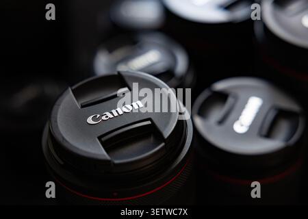 Lemberg, Ukraine - 21. Juni 2026: Gruppe professioneller Canon Kameraobjektive mit Schutzkappen auf dunklem Hintergrund Stockfoto