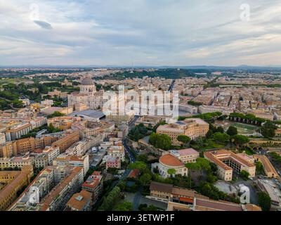 Aus der Vogelperspektive auf den Petersdom und die umliegende Architektur des Vatikans mit historischen Dächern und üppigen Gärten in Rom, Latium, Italien. Stockfoto