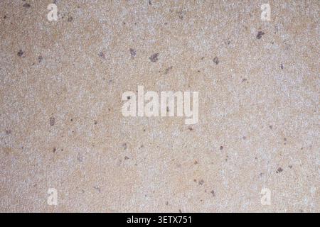 Warme beige, handgefertigte Papierstruktur mit dezenten dunklen Sprenkeln und natürlicher organischer Körnung. Neutraler strukturierter Hintergrund, ideal für umweltfreundliche Verpackungen Stockfoto