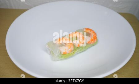 Frischer Salat auf Holzteller. Buntes Grün, Karotten und Tomaten schmücken das Gericht. Rote Kirschtomate auf dem Stapel. Stockfoto