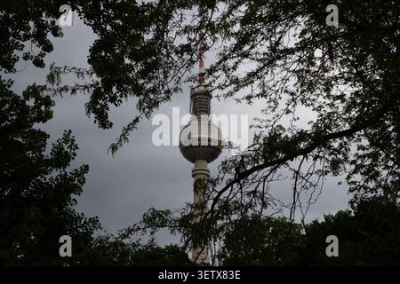 Berlin, Deutschland - Mai 31 2019: Fernsehturm des Berliner Fernsehturms durch dunkle Äste an einem bewölkten Tag gesehen Stockfoto