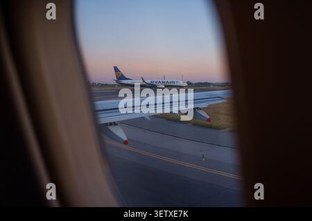 Ein Ryanair-Flugzeug bereitet sich darauf vor, während des Starts durch das Fenster eines anderen Flugzeugs gesehen zu werden. Stockfoto