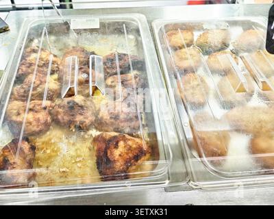 Orenburg, Russland - 22. August 2025: Zwei Tabletts bieten frisch gegrilltes Fleisch und Reisbällchen für Käufer auf einem Markt. Die Kunden sehen sich an Stockfoto