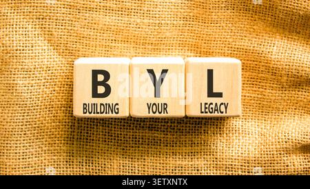 BYL baut Ihr altes Symbol auf. Concept Words BYL baut Ihr Vermächtnis auf wunderschönen Holzblöcken auf. Schöner Leinwandhintergrund. Business BYL Gebäude Stockfoto
