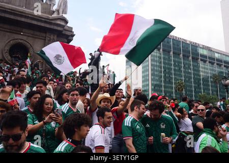 Mexikanische Fans klettern während der WM auf die Statuen des Engels der Unabhängigkeit und schwenken Flaggen. Stockfoto