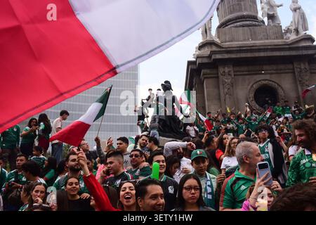 Mexikanische Fans klettern während der WM auf die Statuen des Engels der Unabhängigkeit und schwenken Flaggen. Stockfoto