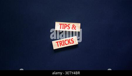 Symbol für Tipps und Tricks. Konzeptwörter Tipps und Tricks auf schönen Holzblöcken. Schöner schwarzer Hintergrund. Geschäftliche Tipps und Tricks Motivation Stockfoto