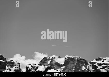 Eine markante, minimalistische horizontale Landschaft in Schwarz und weiß mit den schneebedeckten Gipfeln der Dolomiten in Italien. Stockfoto