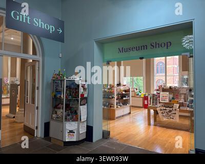 Der Eingang und das Innere des Museumsgeschäfts im Leeds City Museum, Leeds, West Yorkshire, England, mit Warenpräsentationen und Geschenken. Stockfoto