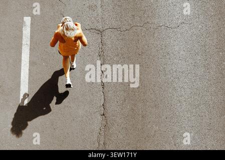 Frau, die auf Asphaltstraße läuft, Blick von oben Stockfoto