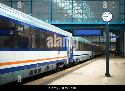 Der moderne Personenzug hielt an einem Bahnsteig im historischen Bahnhof Keleti in Budapest, Ungarn, mit einer Bahnhofsuhr Stockfoto