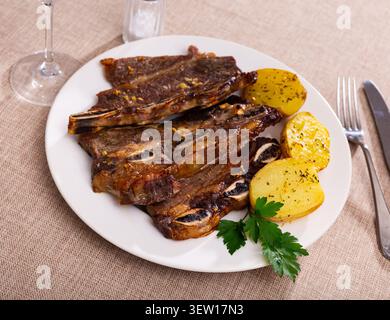 Spanische Küche Churrasco de Ternera, Spare Ribs mit Kartoffeln auf Keramikplatte Stockfoto