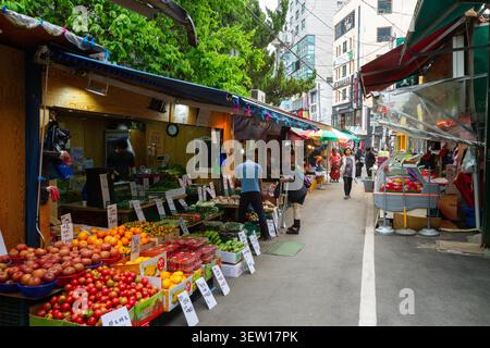 Geschäftige Straßenszene im Freien mit frischen Produkten und Einkaufsmöglichkeiten in Seoul, Südkorea. Stockfoto