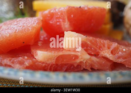 Frische Grapefruitscheiben auf einem Teller mit anderen Früchten Stockfoto