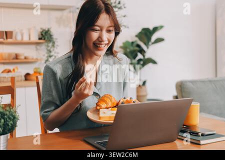 Glück Unternehmer schönes Geschäft asiatische junge Frau tragen lässig Handy zum Einkaufen online genießen Sie mit sozialen Medien und Laptop zu Hause Stockfoto