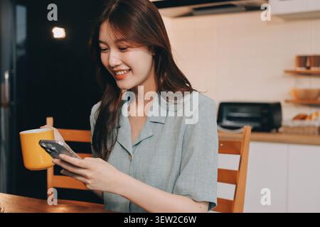 Glück Unternehmer schönes Geschäft asiatische junge Frau tragen lässig Handy zum Einkaufen online genießen Sie mit sozialen Medien und Laptop zu Hause Stockfoto