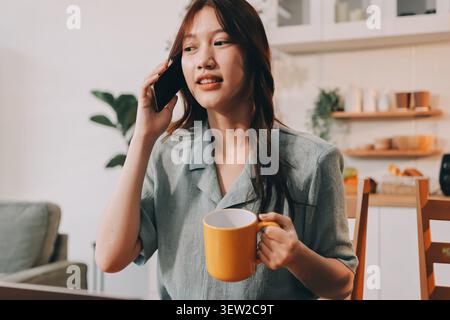 Glück Unternehmer schönes Geschäft asiatische junge Frau tragen lässig Handy zum Einkaufen online genießen Sie mit sozialen Medien und Laptop zu Hause Stockfoto