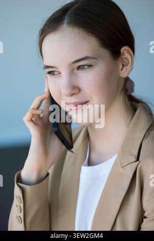 Eine junge Kundin, die ansprechende Telefongespräche führt Stockfoto