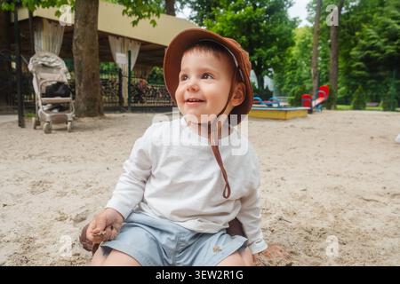 Kleinkind in Sun hat im Sandy Playground Park Stockfoto