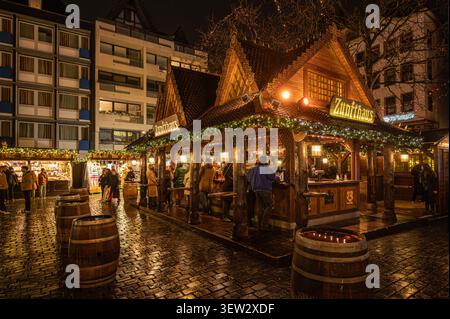Beleuchteter Holzstand namens Zunfthaus auf dem Heinzels Wintermärchen Weihnachtsmarkt bei Nacht in Köln, Deutschland. Stockfoto