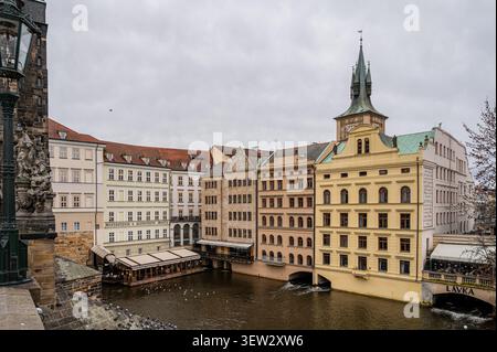 Historische Ufergebäude und der Alte-Stadt-Wasserturm, gesehen über die Moldau von der Karlsbrücke unter einem bewölkten Himmel in Prag, Tsche Stockfoto