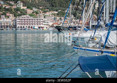 Blick auf festgemachte Segeljachten und Boote im Hafen mit Stadthäusern im Hintergrund bei Tageslicht, Zakynthos, Griechenland. Stockfoto