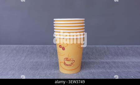 Gestapelte Einweg-Kaffeetassen aus Papier auf grauer Oberfläche Stockfoto