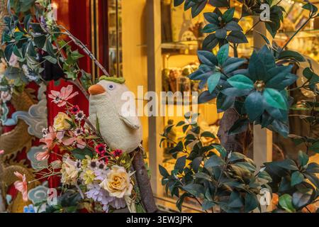 Verspieltes weißes Vogelornament in einer farbenfrohen Schaufensterauslage in Nagasaki Shinchi Chinatown, Nagasaki, Japan. Stockfoto